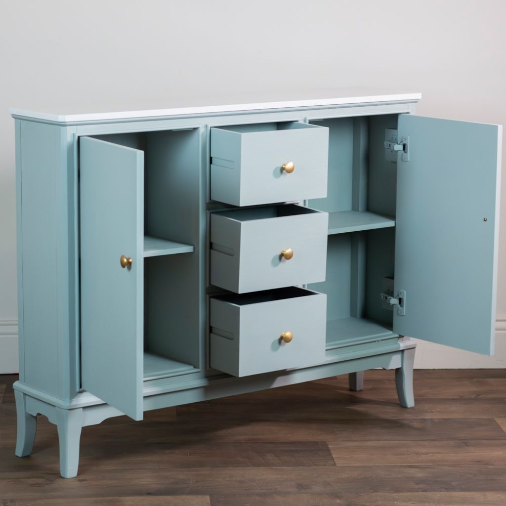 Sage green sideboard with open doors and drawers on a wooden floor.