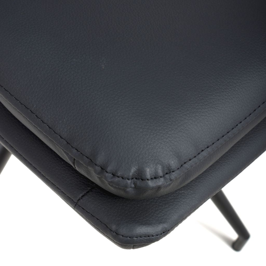 Close-up of a black leather chair seat on a white background