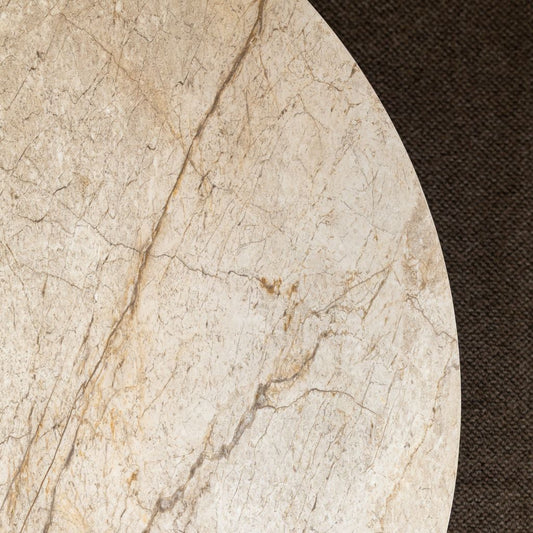 A close-up of the round Naples Dining Table with a Shakespeare Taupe sintered stone top.