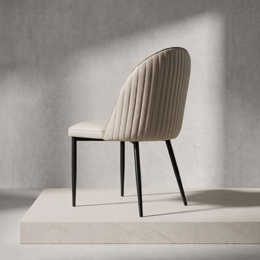 A modern dining chair with a stone PU  ribbed upholstered back and seat, supported by slim black metal legs.