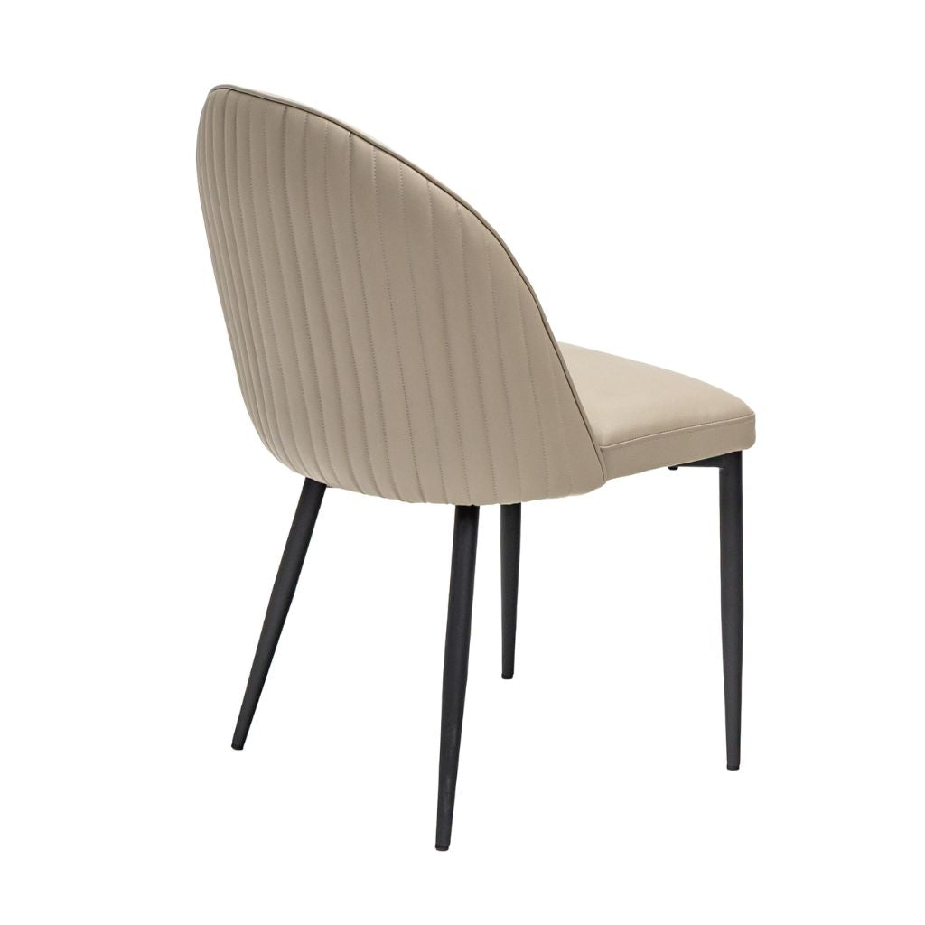 A modern dining chair with a curved, vertical stitching  in a stone PU  with sleek black metal legs, 