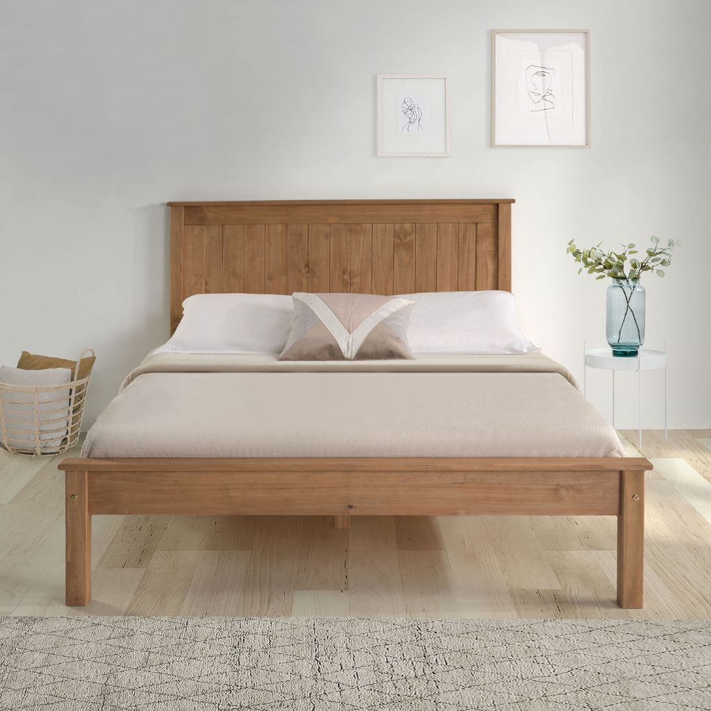 Wooden bed with white bedding in a minimalistic room.