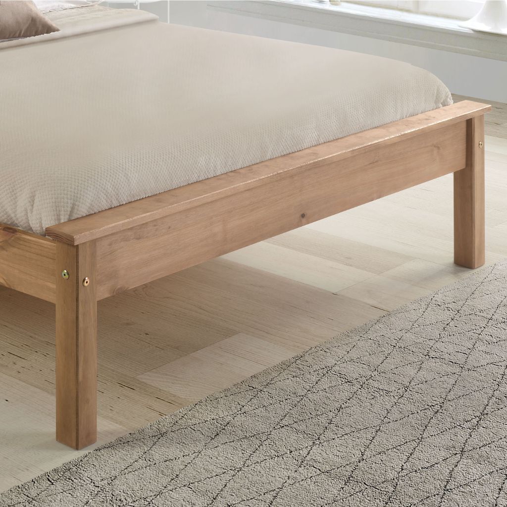 Wooden bed frame with beige mattress on a light wooden floor.