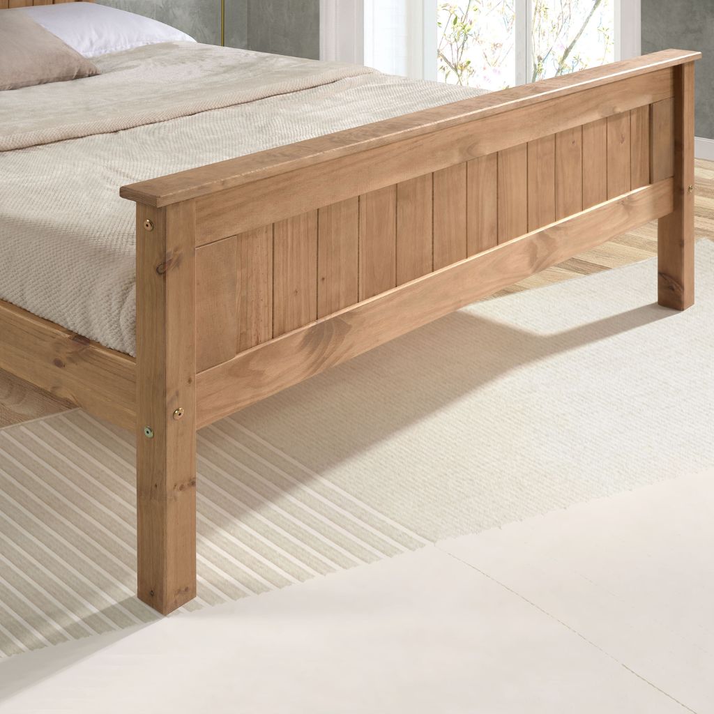 Wooden bed frame with beige bedding on a light wooden floor.
