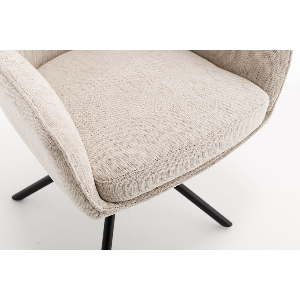 Close-up of a beige upholstered chair with black metal legs on a white background