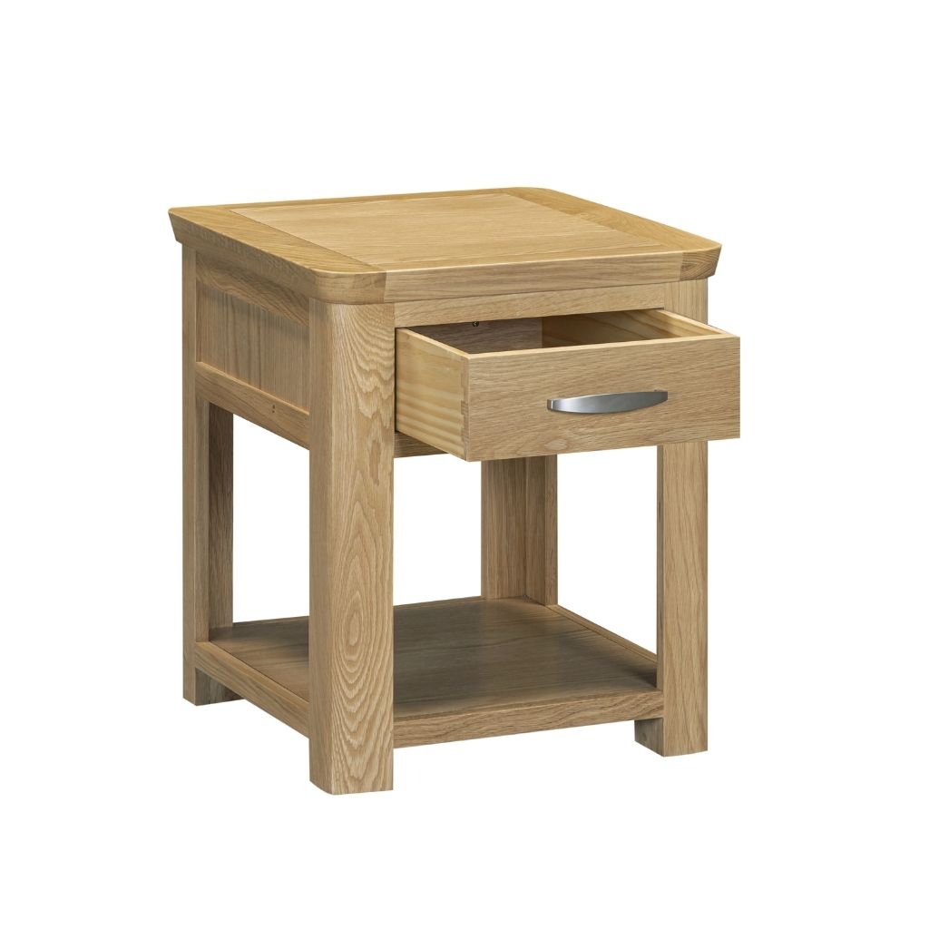 A natural oak wood end table with a single open drawer featuring a silver metal pull handle and an open lower shelf.