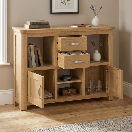 A light natural wood storage cabinet with two drawers, open shelves, and two doors with heaps of storage.