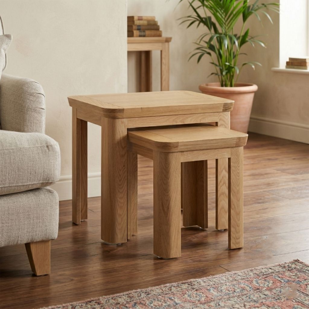 A pair of nesting tables with a natural oak finish