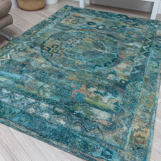 Patterned teal rug on a light wooden floor