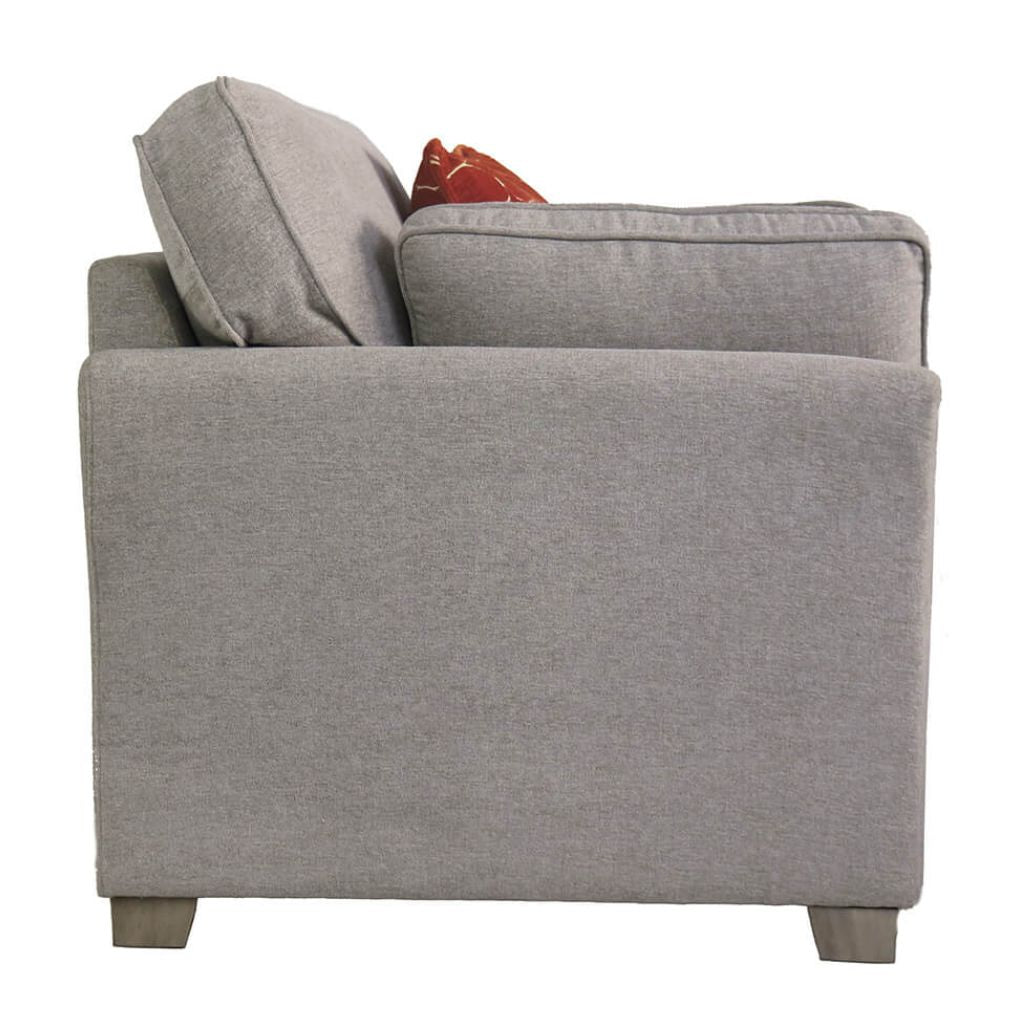 Natural upholstered chair with a red pillow on a white background