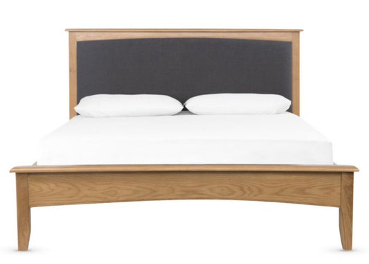 Modern wooden bed with a charcoal grey upholstered headboard.